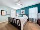 This cozy bedroom boasts a king bed, a ceiling fan, and ample natural light, creating a serene and comfortable retreat at 11013 Leland Groves Dr, Riverview, FL 33579