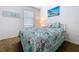 Bedroom featuring a comfortable bed with a beach-themed quilt, complemented by light walls and natural light at 11013 Leland Groves Dr, Riverview, FL 33579