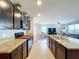 Modern kitchen featuring granite countertops, tile backsplash, dark wood cabinetry, and stainless steel appliances at 11013 Leland Groves Dr, Riverview, FL 33579