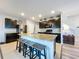 Kitchen with granite countertops, stainless steel appliances, dark cabinetry, and a central island with bar stool seating at 11013 Leland Groves Dr, Riverview, FL 33579