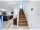 Bright entryway features a carpeted staircase leading upstairs, complemented by a view of the kitchen with stainless steel appliances at 11013 Leland Groves Dr, Riverview, FL 33579