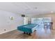 Recreation room features a pool table with cue sticks, chairs, and sliding doors to the exterior at 11200 102Nd Ave # 75, Seminole, FL 33778