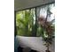 A serene screened balcony filled with lush tropical plants and trees, creating a peaceful retreat at 11201 122Nd Ave # 129, Largo, FL 33778