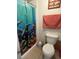 A colorful bathroom featuring a dolphin themed shower curtain and a shell themed picture frame at 11201 122Nd Ave # 129, Largo, FL 33778