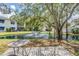 Scenic backyard view featuring a pond with fountain, mature tree, and outdoor seating area at 11440 Harbor Way # 5009, Largo, FL 33774