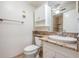 Bathroom with white vanity and beige granite countertop, toilet, mirror and towel rack at 11440 Harbor Way # 5009, Largo, FL 33774