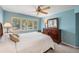 Light blue bedroom with a large window for natural light, a ceiling fan and a wood dresser with mirror at 11440 Harbor Way # 5009, Largo, FL 33774