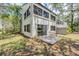 A ground-level view of the back exterior showing a slider to a patio and windows reflecting the trees at 11440 Harbor Way # 5009, Largo, FL 33774