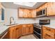 Modern kitchen featuring knotty wood cabinets, stainless steel appliances, and white countertops at 11440 Harbor Way # 5009, Largo, FL 33774