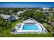 Community pool featuring a jacuzzi, tables, and blue lounge chairs on a sunny day at 11440 Harbor Way # 5009, Largo, FL 33774