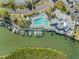 Aerial view of a pool and marina area featuring boat docks, lounge chairs, and a waterfront clubhouse at 11440 Harbor Way # 5009, Largo, FL 33774