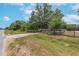 Land with mature trees, a chain-link fence, and a driveway entrance from the road at 12009 Glenshire Dr, Riverview, FL 33579