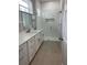 Bright bathroom with double vanity with marble countertop and glass-enclosed shower at 12308 Pittsfield Ave, Tampa, FL 33624