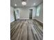 Bright bedroom with wood-look flooring, neutral walls, and modern doorways to other rooms at 12308 Pittsfield Ave, Tampa, FL 33624