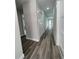 Long hallway with neutral gray walls, white trim, modern flooring, and multiple doors at 12308 Pittsfield Ave, Tampa, FL 33624