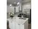 Bright kitchen with white cabinets, stainless steel appliances, a center island, and stylish lighting at 12308 Pittsfield Ave, Tampa, FL 33624