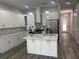 Modern kitchen with white cabinets, stainless steel appliances, center island, and view to the living area at 12308 Pittsfield Ave, Tampa, FL 33624