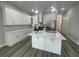 Bright kitchen featuring white cabinets, stainless steel appliances, quartz countertops, and a center island with a sink at 12308 Pittsfield Ave, Tampa, FL 33624