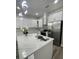 Spacious kitchen with a large island featuring quartz countertops, stainless steel sink and faucet, and modern pendant lighting at 12308 Pittsfield Ave, Tampa, FL 33624
