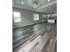 Bright, open living area with modern lighting, large windows, and gray wood-look flooring throughout at 12308 Pittsfield Ave, Tampa, FL 33624
