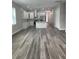 Open floor plan featuring a modern kitchen with an island and sleek, gray wood flooring at 12308 Pittsfield Ave, Tampa, FL 33624