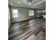 Spacious living room boasting natural light, modern lighting, and stylish gray wood-look flooring at 12308 Pittsfield Ave, Tampa, FL 33624