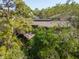 Aerial view of home with deck surrounded by trees and lush greenery at 1296 Weybridge Ln, Dunedin, FL 34698