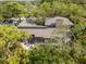 Breathtaking aerial view of the home nestled among lush green trees, showing the property's expansive roof and secluded location at 1296 Weybridge Ln, Dunedin, FL 34698