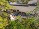 Birds-eye view of home with deck and stairs surrounded by lush greenery at 1296 Weybridge Ln, Dunedin, FL 34698