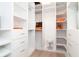 Walk-in closet features custom shelving and drawers for optimal storage space at 1296 Weybridge Ln, Dunedin, FL 34698