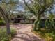 Charming exterior view of home featuring mature landscaping and a spacious brick driveway at 1296 Weybridge Ln, Dunedin, FL 34698