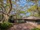 Charming exterior view of home featuring mature landscaping and a spacious brick driveway at 1296 Weybridge Ln, Dunedin, FL 34698