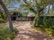 Charming exterior view of home featuring mature landscaping, and a spacious brick driveway at 1296 Weybridge Ln, Dunedin, FL 34698