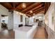 Open kitchen featuring a large island, wood-beamed vaulted ceilings, and stainless steel appliances at 1296 Weybridge Ln, Dunedin, FL 34698