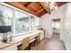 Bright living area showcasing exposed wood beams, a built in desk, and a kitchen with white cabinets at 1296 Weybridge Ln, Dunedin, FL 34698