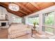 Bright living room features wood-beam ceiling and large windows overlooking the landscaped yard at 1296 Weybridge Ln, Dunedin, FL 34698