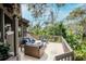 Outdoor deck featuring wicker patio furniture, a brick fire pit, and a panoramic view of the tree canopy at 1296 Weybridge Ln, Dunedin, FL 34698