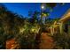 Backyard retreat featuring lush landscaping, brick patio, inviting fire pit area and exterior lighting at 135 12Th Ne Ave, St Petersburg, FL 33701