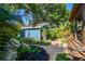 Landscaped backyard with a detached garage, lush foliage, and a brick pathway at 135 12Th Ne Ave, St Petersburg, FL 33701