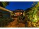 Backyard retreat with brick patio, fire pit, pergola and lush landscaping with exterior lighting at 135 12Th Ne Ave, St Petersburg, FL 33701