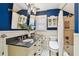 Bathroom features granite counters, dual sinks, blue walls, and shower with curtain at 135 12Th Ne Ave, St Petersburg, FL 33701