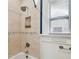 Shower and tub with tile surround, shower head, and window at 135 12Th Ne Ave, St Petersburg, FL 33701