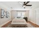 Bright bedroom boasts neutral walls, ceiling fan, bench, and hardwood floors at 135 12Th Ne Ave, St Petersburg, FL 33701