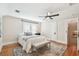 Bright bedroom features a ceiling fan, bench, window and hardwood floors at 135 12Th Ne Ave, St Petersburg, FL 33701