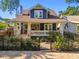 Charming two-story home featuring a welcoming front porch, complemented by a manicured front yard and wrought iron fence at 135 12Th Ne Ave, St Petersburg, FL 33701