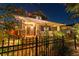 Charming home exterior featuring a well-lit porch, manicured landscaping, and an elegant wrought iron fence at 135 12Th Ne Ave, St Petersburg, FL 33701
