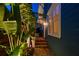 Side view of home exterior with brick pathway, lush tropical plants and warm exterior lighting at 135 12Th Ne Ave, St Petersburg, FL 33701