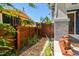 Landscaped side yard with brick pathway and privacy fence leading to the home at 135 12Th Ne Ave, St Petersburg, FL 33701