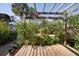Landscaped backyard area with a pergola, raised wood platform, and lush plantings at 13511 Avista Dr, Tampa, FL 33624