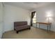 Bright bedroom features neutral carpet, versatile couch and a desk by a sunlit window at 13511 Avista Dr, Tampa, FL 33624